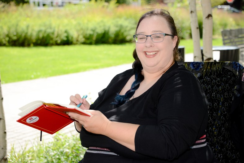 Nyla writing outside. Hair in a twist.