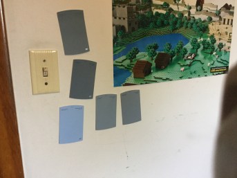 Blue and blue-gray paint samples on a wall.